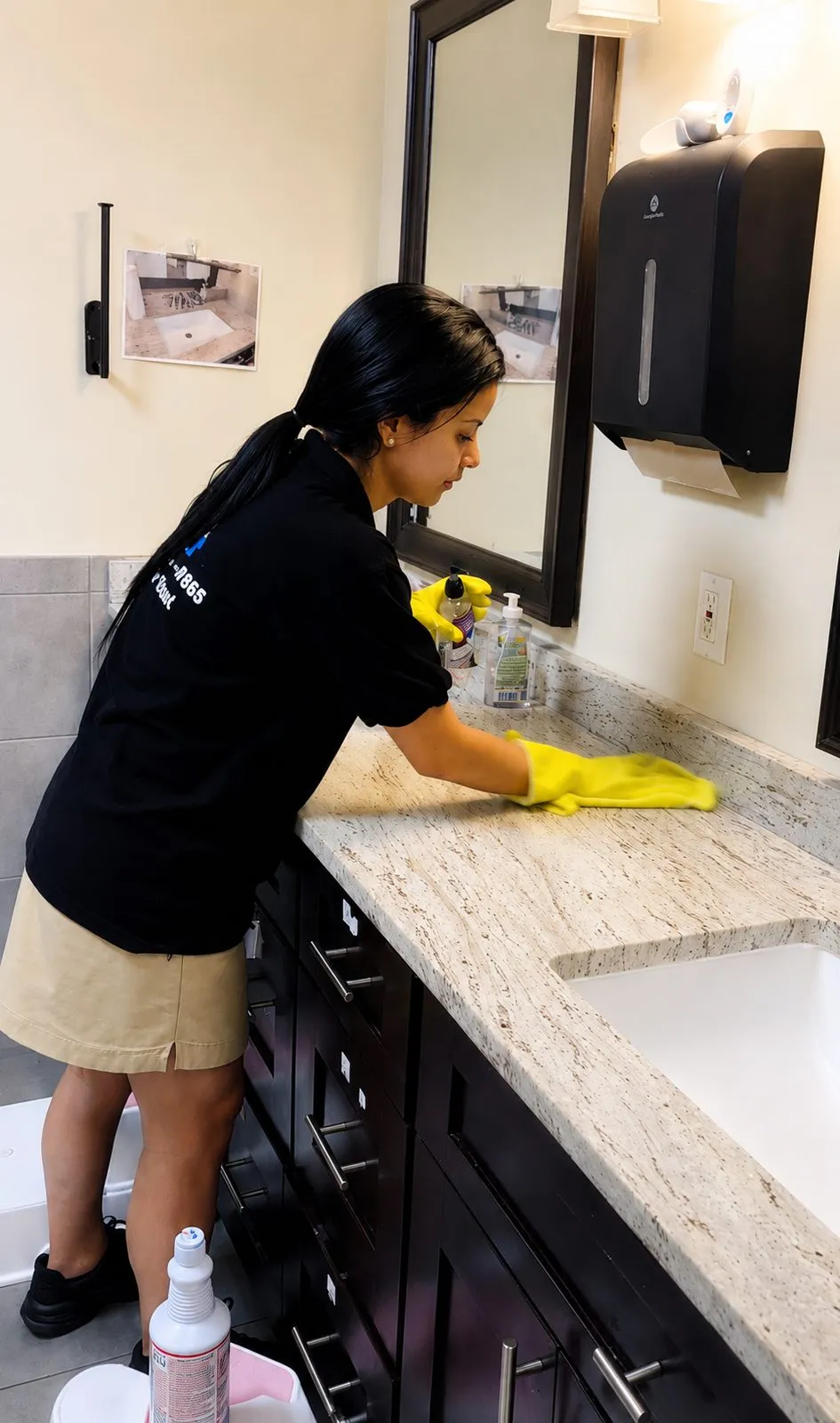 Team member wiping a granite bathroom vanity